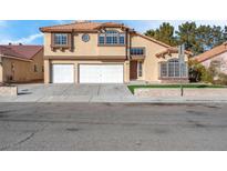 Two-story stucco home with a three-car garage and desert landscaping at 6586 W Mesa Vista Ave, Las Vegas, NV 89118