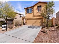 Two-story tan home with a concrete driveway and desert landscaping in a residential neighborhood at 1012 Water Cove St, Henderson, NV 89011