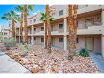 Two-story building with multiple units, desert landscaping, and palm trees at 2044 Mesquite Ln # 302, Laughlin, NV 89029