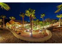 Stunning backyard oasis with lush tropical landscaping, ambient lighting, and a serene atmosphere at 2064 Poetry Ave, Henderson, NV 89052