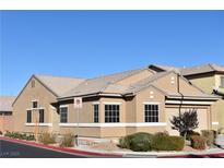 Tan one-story house with a two-car garage and landscaped yard at 304 Whitney Breeze Ave, North Las Vegas, NV 89031