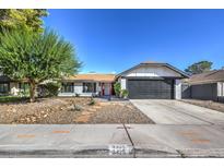 Single story home with gray garage door and red front door at 3425 Irv Marcus Dr, Las Vegas, NV 89108