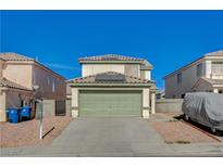 Two-story house with a green garage door and a landscaped front yard at 6536 Elk Creek Ln, Las Vegas, NV 89156