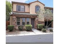 Two-story townhome with stone accents and landscaped front yard at 8396 Waylon Ave, Las Vegas, NV 89178