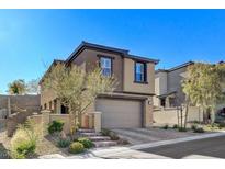 Contemporary two-story home featuring a neutral color scheme, attached two-car garage, and manicured landscaping at 889 Ariel Heights Ave, Las Vegas, NV 89138