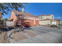 Two-car garage with driveway and landscaping; view of a house's exterior at 9008 Rusty Rifle Ave, Las Vegas, NV 89143