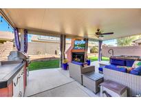 Inviting outdoor space with fireplace, TV, grill, and stylish seating area perfect for relaxing and entertaining at 3740 Corte Bella Hills Ave, North Las Vegas, NV 89081