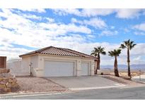 Two-car garage, desert landscaping, and a two-story home with a tile roof at 53 Flowering Desert Dr, Palm Gardens, NV 89039