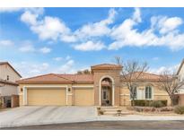 Tan house with three-car garage and landscaped yard at 6545 Candleglade Ct, North Las Vegas, NV 89084