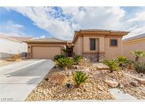 Single-story home with desert landscaping and two-car garage at 7830 Lyrebird Dr, North Las Vegas, NV 89084