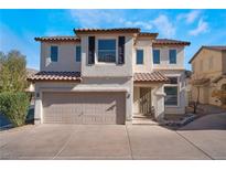 Two-story house with tan exterior, brown roof, and a two-car garage at 10441 Concetta Ave, Las Vegas, NV 89129