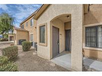 Tan two-story building with a walkway and landscaping at 2051 Hussium Hills St # 207, Las Vegas, NV 89108