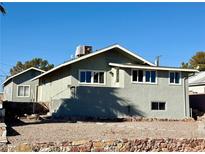 Gray house with a smaller building in the back, and a gravel yard at 624 D Ave, Boulder City, NV 89005