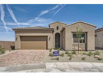 Charming single-story home featuring a two-car garage, desert landscaping, and a tiled roof in a sunny setting at 66 Ibiza Lake Dr, Henderson, NV 89011