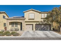 Two-story house with stone accents, solar panels, and a two-car garage at 7528 Stray Horse Ave, Las Vegas, NV 89113