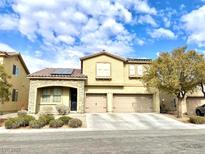 Two-story house with solar panels, two-car garage, and landscaped front yard at 7528 Stray Horse Ave, Las Vegas, NV 89113