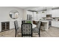 Modern kitchen with stainless steel appliances, a wine fridge, and stylish chairs at 104 Alamere Falls Dr, Las Vegas, NV 89138