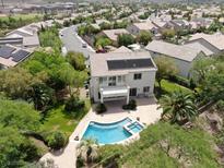 Aerial view of two-story house with pool and solar panels, surrounded by lush landscaping at 1327 Coulisse St, Henderson, NV 89052