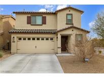 Two-story house with beige exterior, brown accents, and a two-car garage at 4904 Siglo St, North Las Vegas, NV 89031