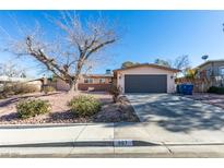 Ranch style home with a large tree and updated garage door at 607 Sierra Ln, Henderson, NV 89002