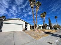 House exterior showcasing a white garage door and palm trees in the front yard at 6552 Boxwood Ln, Las Vegas, NV 89103