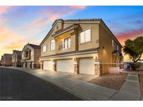 Charming townhome with a three-car garage and desert landscaping at sunset at 6752 Lookout Lodge Ln # 1, North Las Vegas, NV 89084