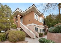 Inviting two-story condo with desert landscaping and stucco exterior with exterior stairs leading to the front door at 830 Carnegie St # 1821, Henderson, NV 89052