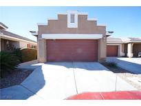 Exterior shot featuring a two-car garage, wide driveway, and desert landscaping against a blue sky at 1025 Chestnut Bay Ave, North Las Vegas, NV 89031