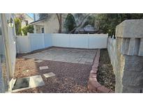 Cozy backyard with brick-lined flower bed and decorative pavers, perfect for outdoor relaxation at 10337 Adams Chase St, Las Vegas, NV 89183