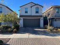 Inviting two-story home with a gray color scheme, a paved driveway, and well-maintained landscaping at 365 Andy Wheeler Dr, Henderson, NV 89011