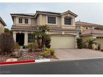 Two-story house with attached garage and landscaped front yard at 10894 Calcedonian St, Las Vegas, NV 89141