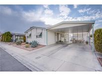 Single-wide manufactured home with carport and landscaped front yard at 3209 Tularosa Ln, Las Vegas, NV 89122