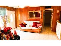 Cozy living room features wood paneling, a large mirror and a comfortable sofa at 4130 Balboa Ave, Las Vegas, NV 89121