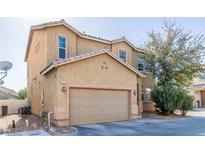 Two-story house with tan exterior, two-car garage, and landscaping at 5373 Sleeping Cat St, Las Vegas, NV 89122