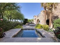 A luxurious pool area with a spa offers a tranquil retreat surrounded by lush landscaping and stone accents at 641 Saint Croix St, Henderson, NV 89012