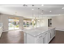 Spacious kitchen with island, stainless steel appliances, and white cabinets at 8797 Pinley Spring St, Las Vegas, NV 89113