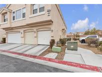 Charming townhouse exterior with private garages and well-maintained landscaping at 9323 Leaping Deer Pl # 102, Las Vegas, NV 89178