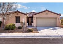 Single-story house with tan exterior, tile roof, and two-car garage at 2595 Fountain Ave, Pahrump, NV 89048