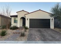 One-story home with a dark gray garage door and a landscaped front yard at 6842 Laguna Blanca St, North Las Vegas, NV 89086