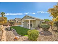 Landscaped backyard with artificial turf and covered patio at 10282 Country Flats Ln, Las Vegas, NV 89135