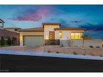 Modern single-story home with light-colored stone exterior and landscaped yard at 11700 Belorado Ave, Las Vegas, NV 89138