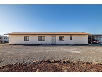 A single-story home with a desert landscape and a covered carport at 3381 W Simkins Rd, Pahrump, NV 89060