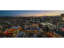 Aerial view of cityscape at dusk, showing city lights and mountain range in background at 150 Las Vegas Blvd # 1909, Las Vegas, NV 89101