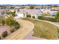 Single-story house with a large yard, long driveway, and detached garage at 1920 Cavalry St, Pahrump, NV 89048