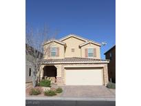 Two-story house with beige exterior, attached garage, and landscaping at 242 Botanic Gardens Dr, Las Vegas, NV 89148