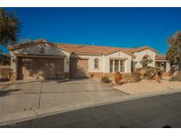 Single-story home with a two-car garage and desert landscaping at 328 Hedgehope Dr, Las Vegas, NV 89183