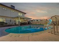 Inviting backyard pool with slide and covered patio area, perfect for outdoor entertaining and relaxation under a colorful sky at 4008 Snead Dr, Las Vegas, NV 89107