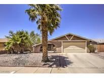 Single story home with a two-car garage and desert landscaping at 427 Shamrock Dr, Henderson, NV 89002