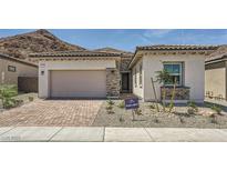 Charming single-story home with a two-car garage, stone accents, and a desert-landscaped front yard at 65 Ibiza Lake Dr, Henderson, NV 89011