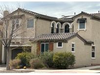 Tan two-story house with solar panels, arched windows, and landscaped yard at 7561 Tamany St, Las Vegas, NV 89143